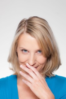 Studio shot of mid adult woman covering lips. Photo : Rob Lewine