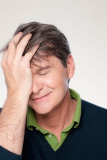 Studio portrait of mature man with head in hands. Photo : Rob Lewine