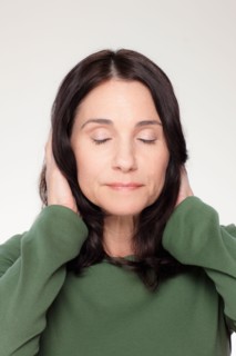 Studio portrait of mature woman covering ears. Photo : Rob Lewine