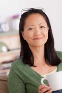 Portrait of woman holding cup. Photo : Rob Lewine