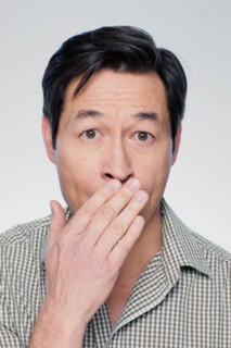 Studio portrait of mature man covering mouth. Photo : Rob Lewine