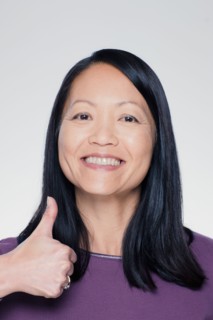 Studio portrait of mature woman showing thumbs up sign. Photo : Rob Lewine
