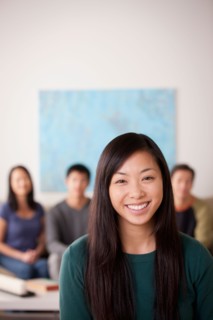 Portrait of young woman with family in background. Photo : Rob Lewine