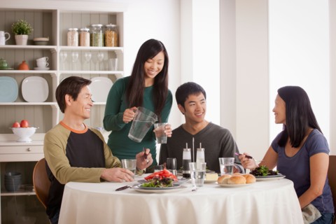Happy family having meal together. Photo : Rob Lewine