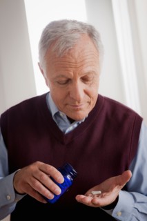 Senior man holding medicine bottle. Photo : Rob Lewine
