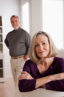 Portrait of smiling senior woman, senior man in background. Photo : Rob Lewine
