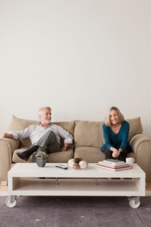 Happy senior couple sitting on sofa. Photo : Rob Lewine