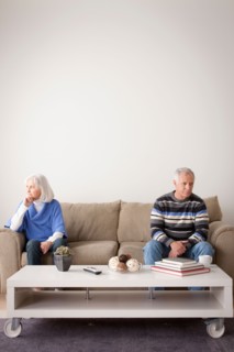 Angry senior couple sitting on sofa. Photo : Rob Lewine