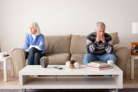Angry senior couple sitting on sofa. Photo : Rob Lewine