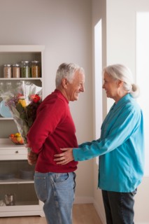 Senior man giving flower to woman. Photo : Rob Lewine