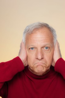 Studio shot of senior man covering ears. Photo : Rob Lewine