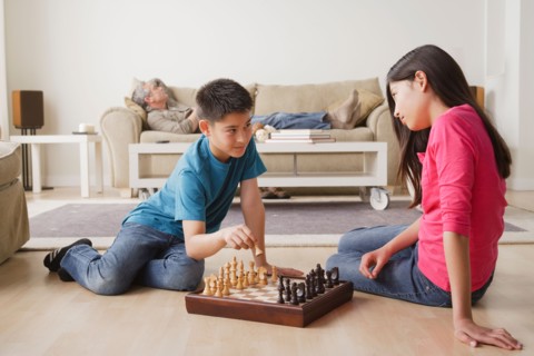 Siblings playing chess game. Photo : Rob Lewine