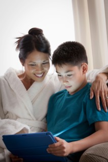 Mother embracing son using laptop. Photo : Rob Lewine