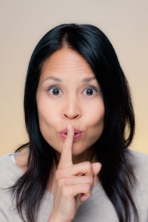Portrait of woman making silence gesture. Photo : Rob Lewine
