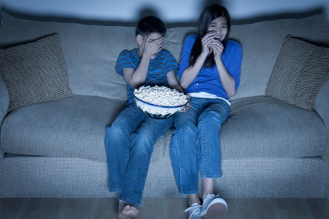 Brother and sister (10-11, 12-13) watching television. Photo : Rob Lewine