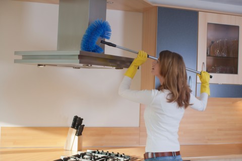 Young woman cleaning the kitchen. Photo : Mark de Leeuw
