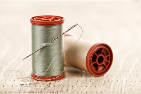 Spool of thread and needle. Photo : Elena Elisseeva