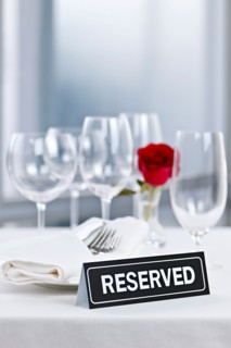Dishes and cutlery prepared for meal in restaurant with reserved sign. Photo : Elena Elisseeva