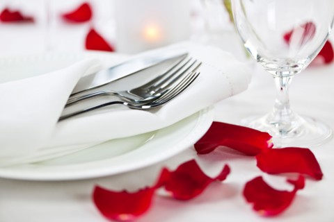 Dishes and cutlery prepared for meal decorated with red roses. Photo : Elena Elisseeva