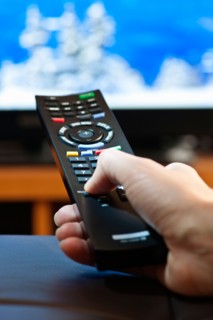 Human hand holding remote control . Photo : Elena Elisseeva