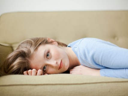 Indoor portrait of young attractive woman reclining on sofa. Photo : Jessica Peterson