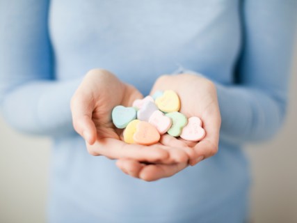 Young woman showing handful of cookie hearts. Photo : Jessica Peterson