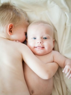 Happy young boy (2-3) embracing baby brother (6-11 months). Photo : Jessica Peterson