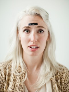 Portrait of young woman with word help on forehead. Photo : Jessica Peterson