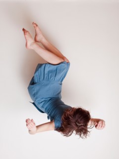 Young woman wearing blue dress falling upside down. Photo : Jessica Peterson