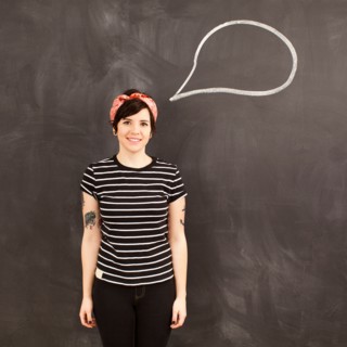 Portrait of young woman in front of blackboard. Photo : Jessica Peterson