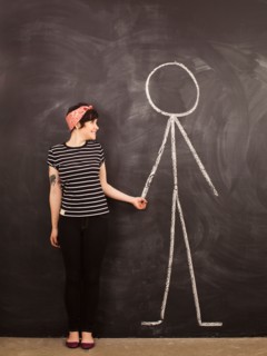 Portrait of young woman in front of blackboard. Photo : Jessica Peterson