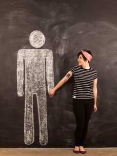 Portrait of young woman in front of blackboard. Photo : Jessica Peterson
