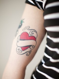 Heart shaped tattoo on woman's arm. Photo : Jessica Peterson