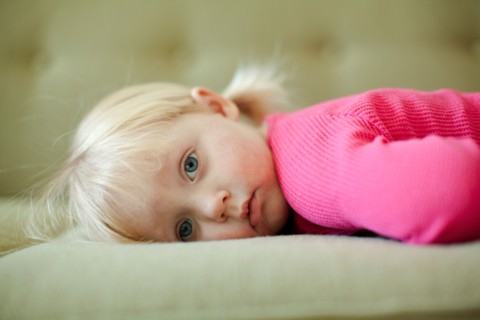 Portrait of baby girl (18-23 months) resting on sofa. Photo : Jessica Peterson
