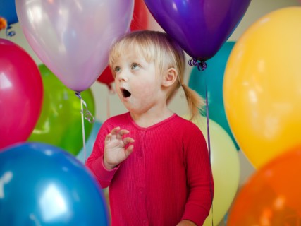 Portrait of baby girl (18-23 months) wit colorful balloons. Photo : Jessica Peterson