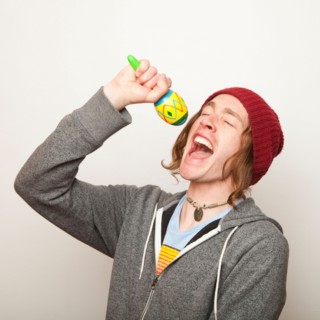 Studio Shot of young man pretending to sing. Photo : Jessica Peterson