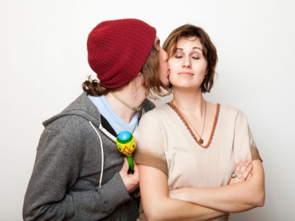 Studio Shot of young man kissing young woman. Photo : Jessica Peterson