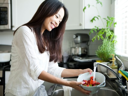 Portrait of young woman washing strawberries. Photo : Jessica Peterson