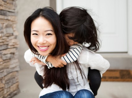 Smiling woman embracing by her daughter (4-5). Photo : Jessica Peterson