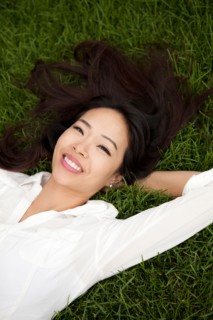 High angle view of smiling woman lying on lawn. Photo : Jessica Peterson