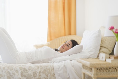 Young woman lying on bed.
