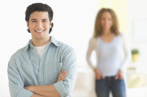 Portrait of couple with focus on man in foreground.