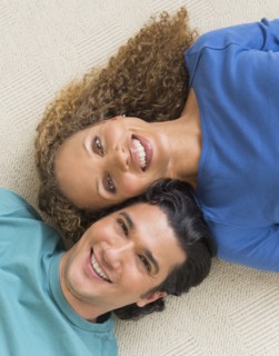 Portrait of couple lying on floor.