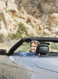 USA, California, Joshua Tree National Park, Young woman driving convertible.