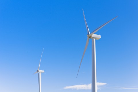 Wind turbines against blue sky.