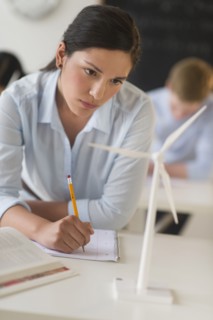 Female student examining wind turbine.