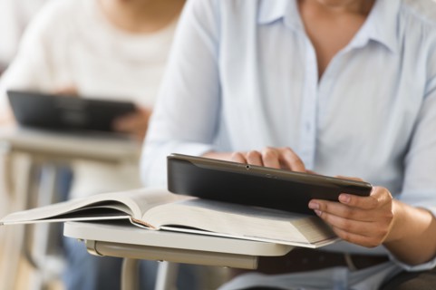 Students (14-19) using digital tablets.