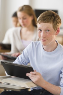 Students (14-17) using digital tablets at school.