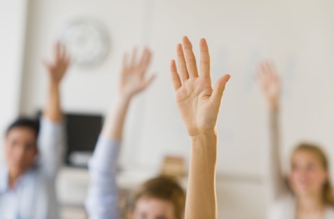 Students (14-19) raising hands.