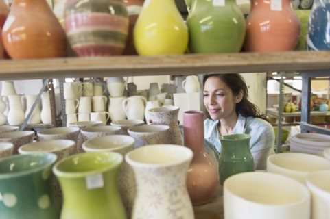Female artist in pottery in studio.